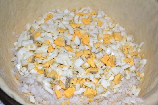 слой риса, а сверху него выкладываем яйца