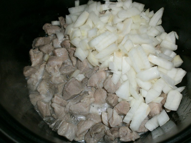 Затем к мясу добавляем мелко нарезанный лук и обжариваем еще 10 минут