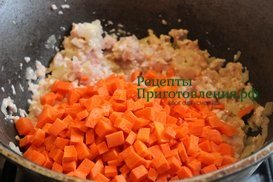 Морковь нарезаю кубиками и добавляю в казан к луку и куриному фаршу