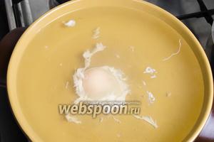 Разбить яйцо о край сотейника резким ударом до образования трещины. Широко раскрыть скорлупу и вылить яйцо в воду. (Быстро установить таймер на 4 минуты!) Если белок не плотно окружит желток, осторожно подкрутить ложкой воду возле яйца.