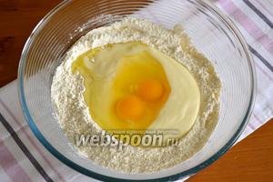 В центре сделать углубление, вылить в него жидкую смесь и разбить 2 яйца.