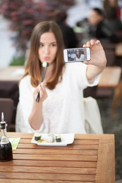 Молодая женщина, принимая Автопортрет в суши-ресторане — стоковое фото