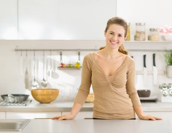 Портрет улыбающийся молодой домохозяйки в современной кухне — стоковое фото