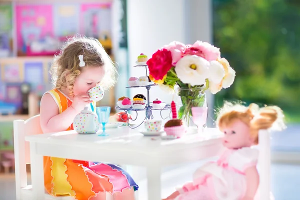 Малыш девочка играет чаепития с куклой — стоковое фото