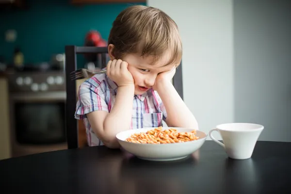 Обиженный маленький мальчик отказывается есть ужин — стоковое фото