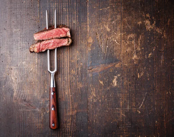 Стейк из говядины на мясо вилкой Лицензионные Стоковые Фото