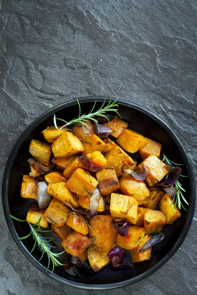 Жареный сладкий картофель с луком и розмарином — стоковое фото