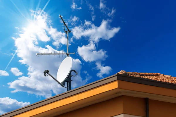 Спутниковые тарелки и антенна tv на голубое небо — стоковое фото
