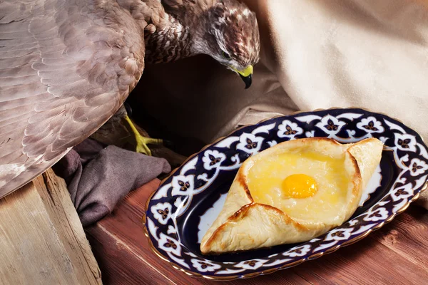 Khachapuri meal oriental plate with egg isolated Uzbek dishes stuffed eagle, taxidermy, — стоковое фото