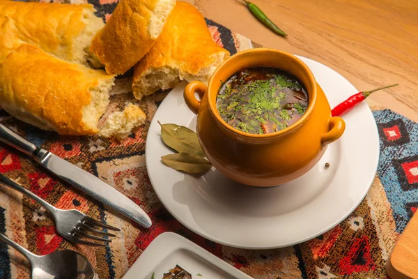 Горячие, пряный суп, куриный бульон с травами и специями в глиняном горшочке — стоковое фото