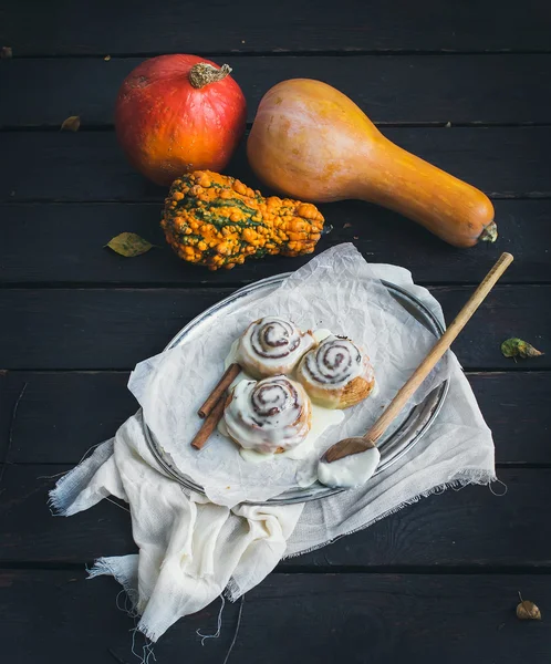 Тыквенные булочки с корицей с сливочным сыром обледенения и спелые тыквы Стоковое Изображение
