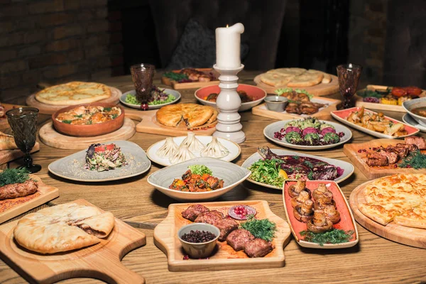 Много пищи на деревянный стол. Грузинская кухня. Вид сверху. Заложить квартиру. Хинкали и грузинские блюда — стоковое фото