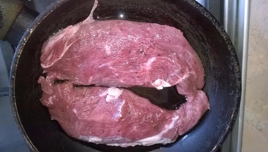 Выкладываем мясо в сковороду и начинаем обжаривать