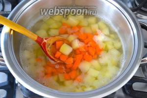 Тем временем нарезаем морковь и добавляем в кастрюлю к картофелю. 