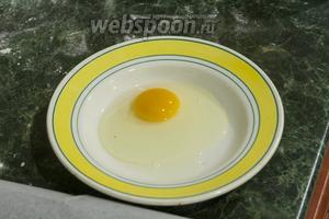 Разобьём в тарелку куриное яйцо.