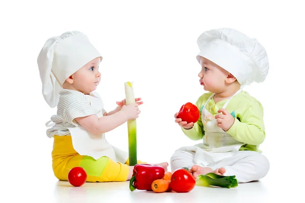 Маленький мальчик и девочка, носящая шляпу повара со здоровой едой vegeta — стоковое фото
