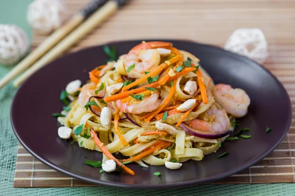 Азиатская лапша с креветками, овощи, морковь, арахис, лук — стоковое фото