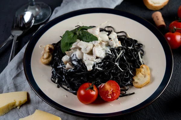 Традиционное итальянское блюдо. Спагетти с чернилами каракатицы и сливочным соусом с грибами Лицензионные Стоковые Изображения